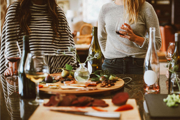 a group of people at a grazing plate with matching wine