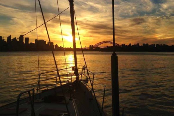 View from a sailing yacht coming into the iconic Sydney Harbour at sunset