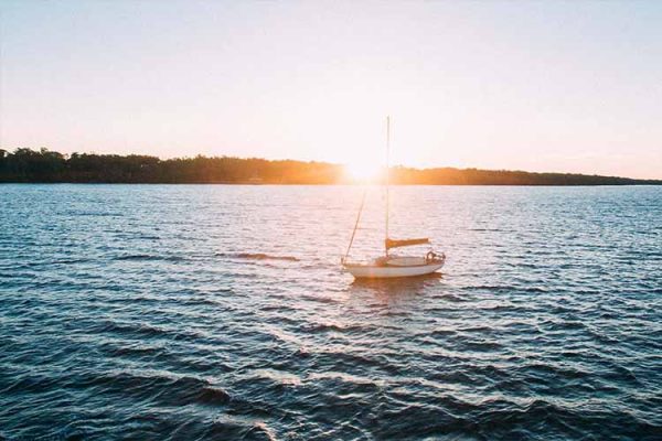 A sailing boat on the water at sunset